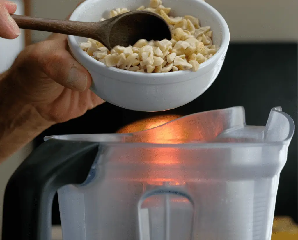 ADDING BLANCHED CASHEWS TO BLENDER FOR CLASSIC VEGAN MAYO