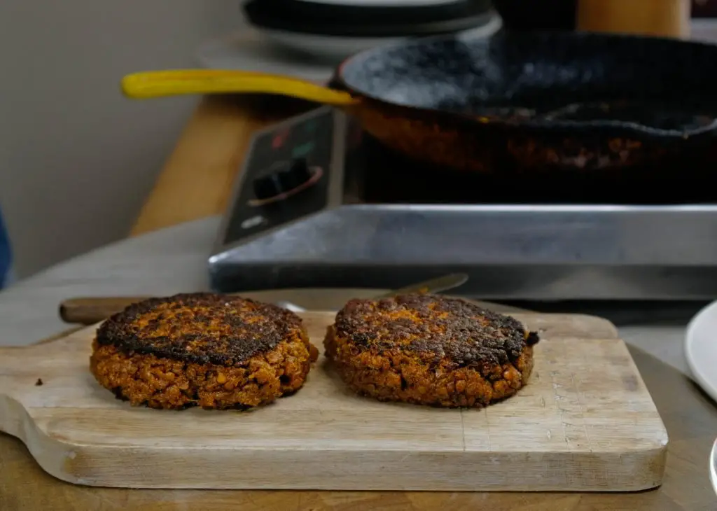 COOKED LENTIL BUGER PATTIES ON CUTTING BOARD