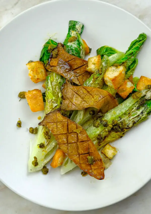 CHARD CEASAR ROMAINE SALAD WITH KING OYSTER MUSHROOMS, GARLIC CROUTONS, CHEESY CAPERS