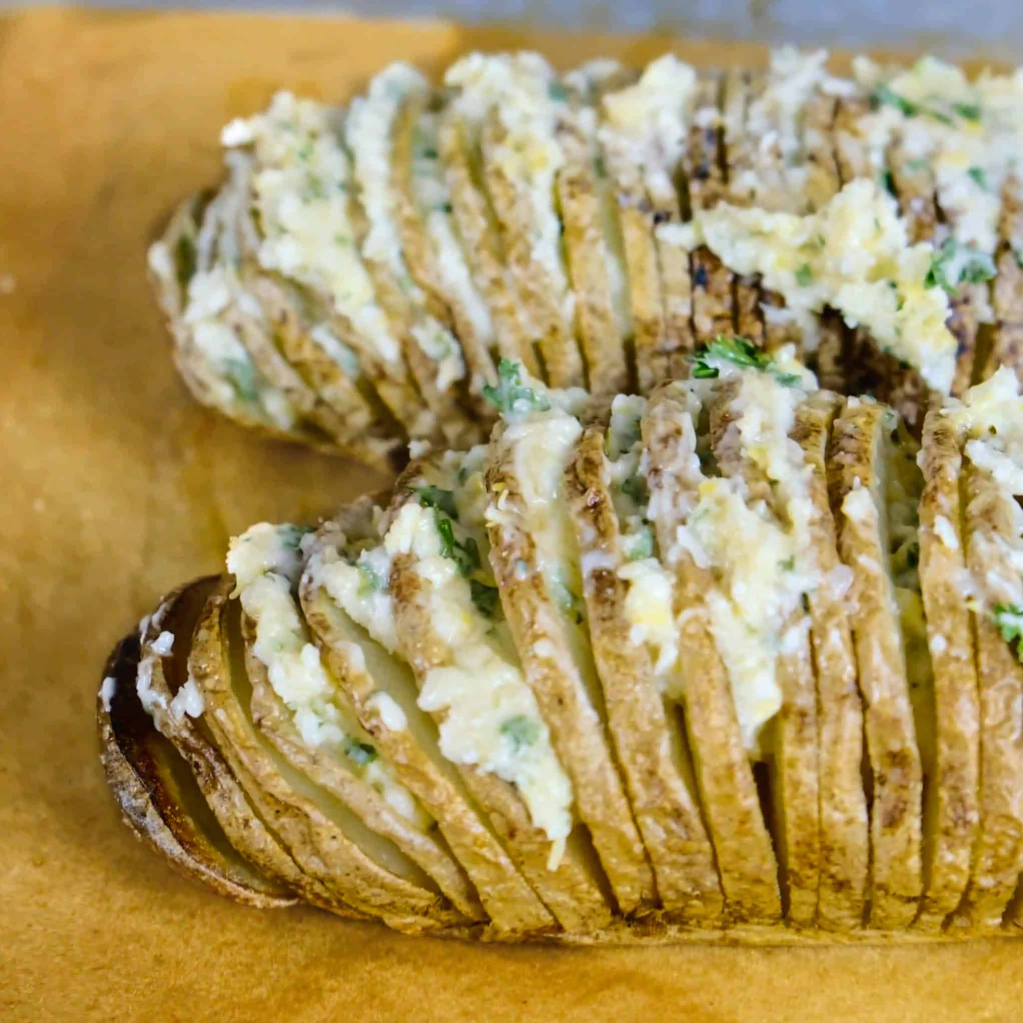 baked hasselback potato with herb vegan butter_