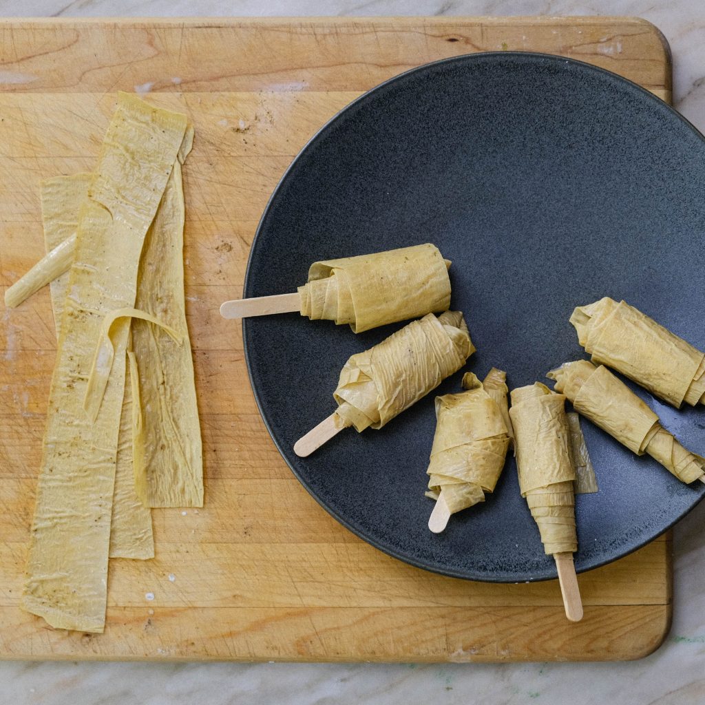 WRAPPING TOFU SKIN STRIPS AROUND STICK FOR VEGAN CHICKEN DRUMETTES