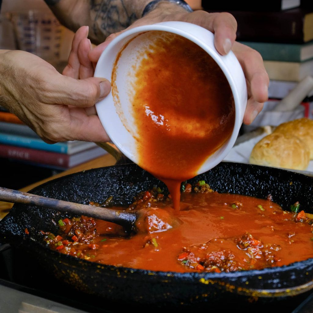 ADDING TOMATO SAUCE TO ONIONS, GARLIC, RED BELL PEPPERS, SPICES, TOMATO PASTE, GOCHUJANG KOREAN SLOPPY JOES_